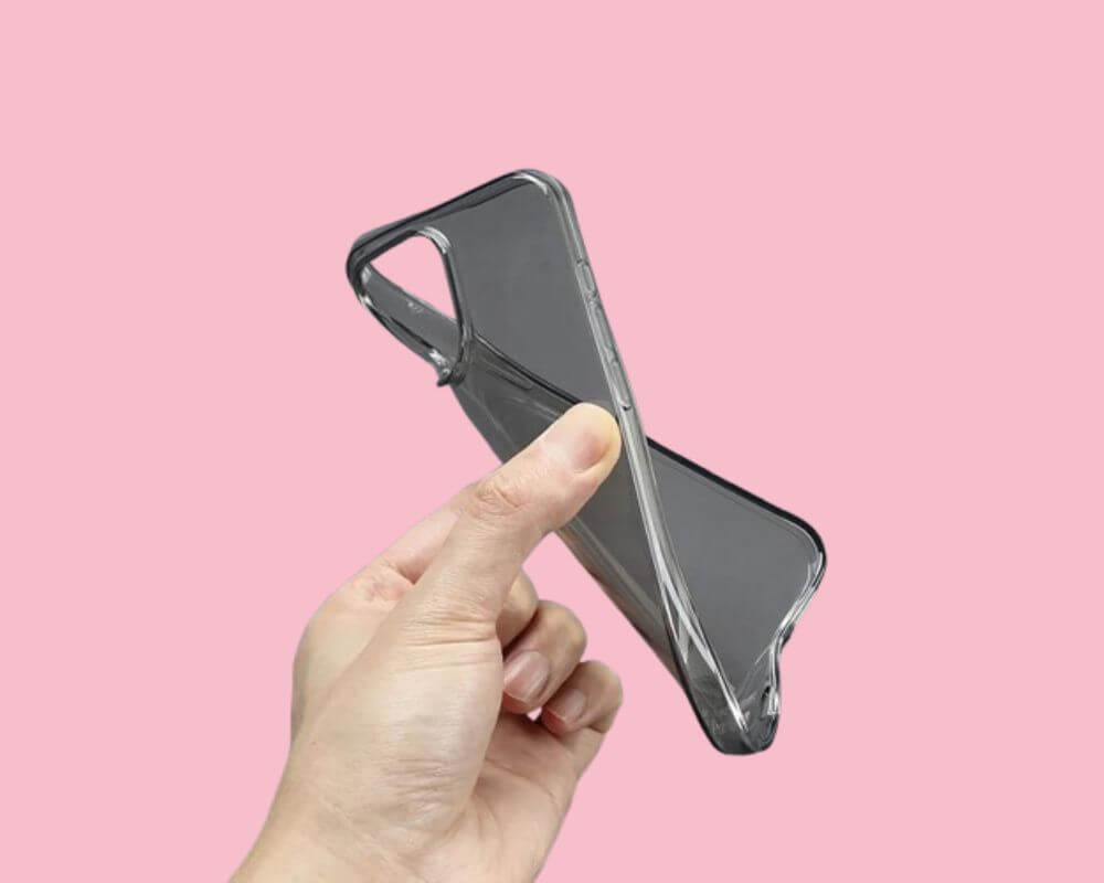 A flexible, transparent phone case being bent by a hand, showcasing its soft and pliable material