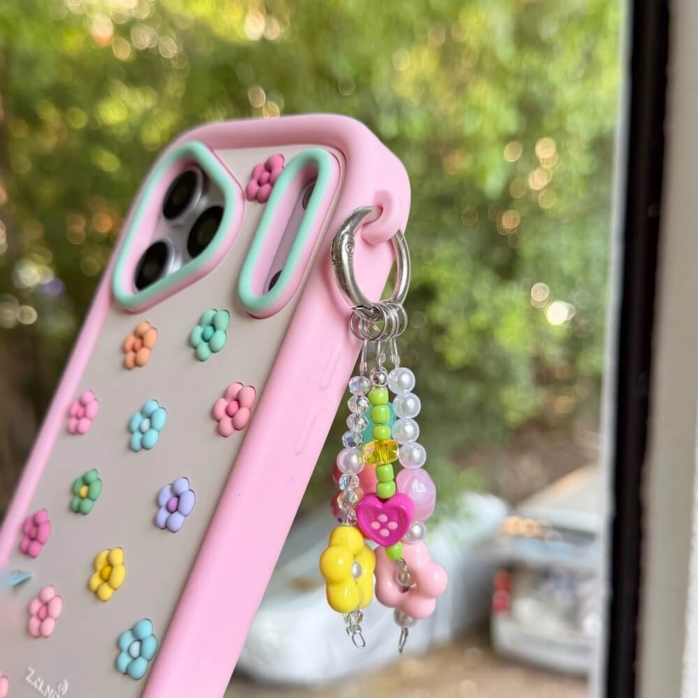 Pink iPhone case with colorful 3D flowers and a silicone bumper
